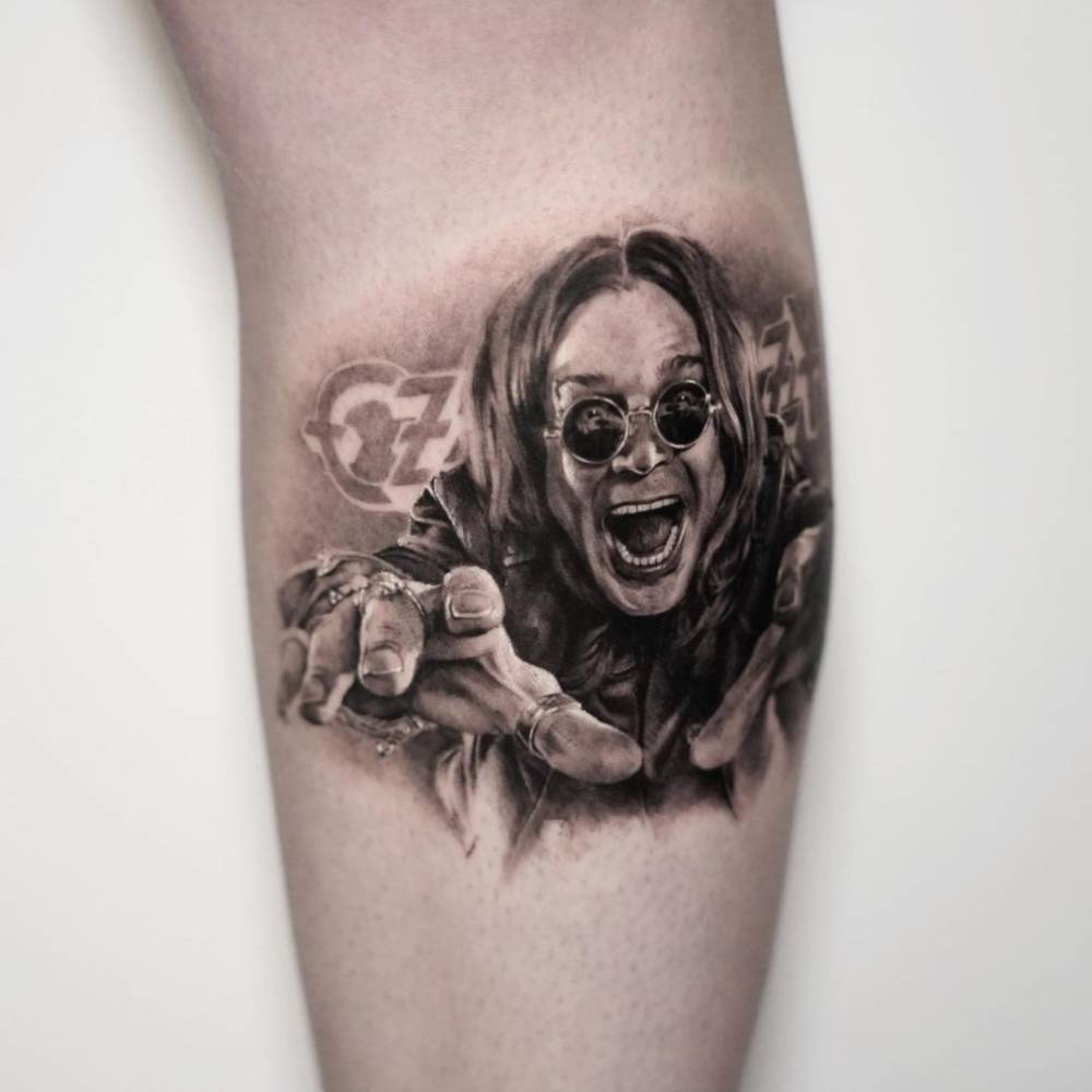 Black and grey Ozzy Osbourne portrait tattoo on the calf.
