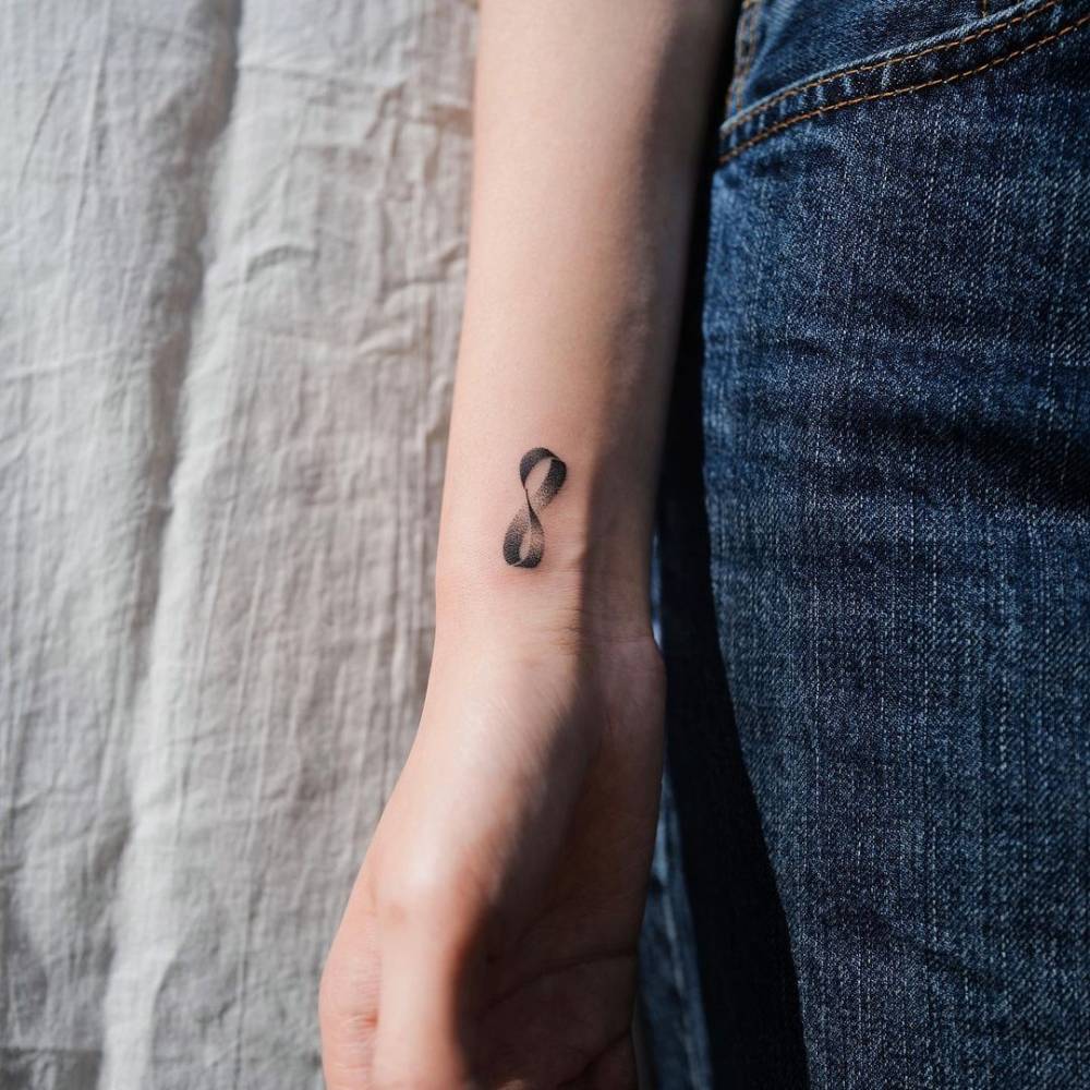 Dotwork mobius strip tattoo on the wrist.