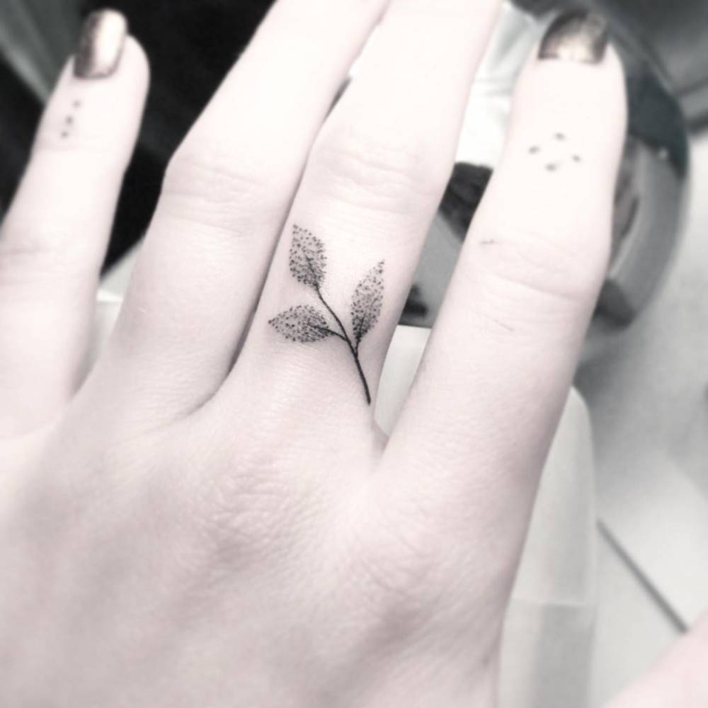 Dotwork sprig tattoo on the finger.