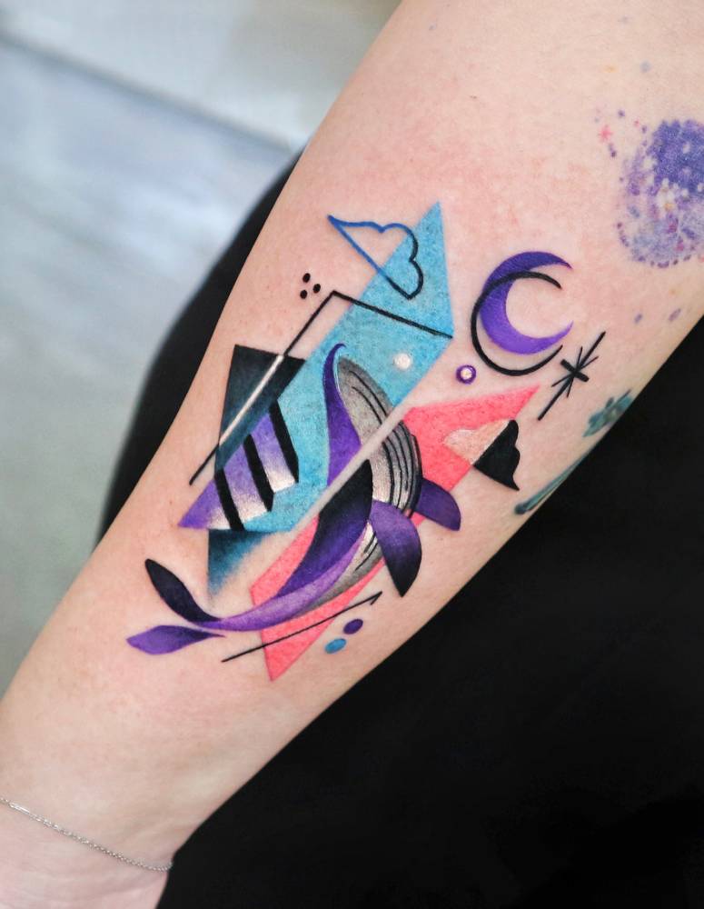 Whale tattoo in graphic style located on the inner forearm.