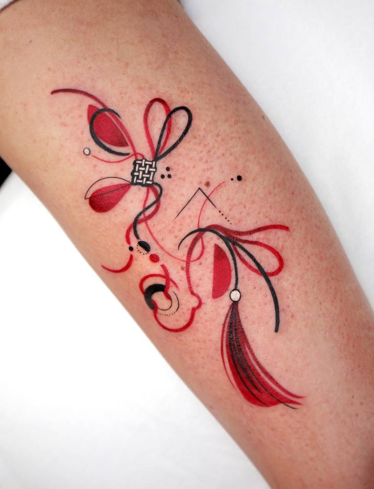 Norigae tattoo in illustrative style located on the upper arm.