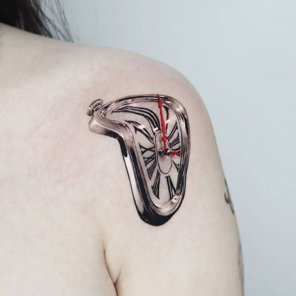 Micro-realistic style Dali's clock tattoo located on the shoulder.