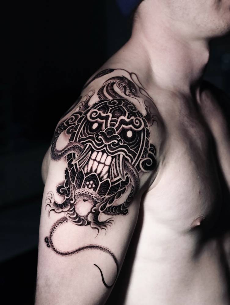Dokkaebi tattoo located on the upper arm and shoulder, oriental style.