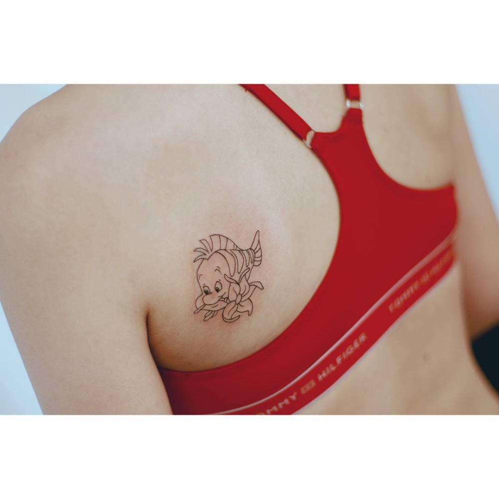 Flounder tattoo in fine line style located on the shoulder blade.
