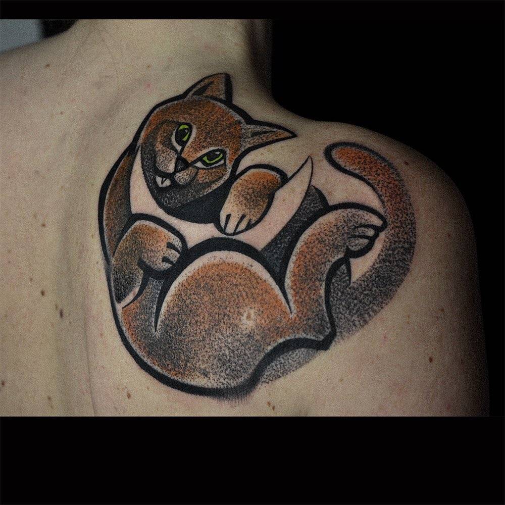 Cat tattoo on the shoulder blade.