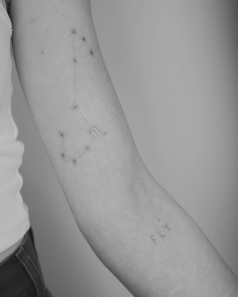 Scorpius constellation and initials tattooed on the the arm.