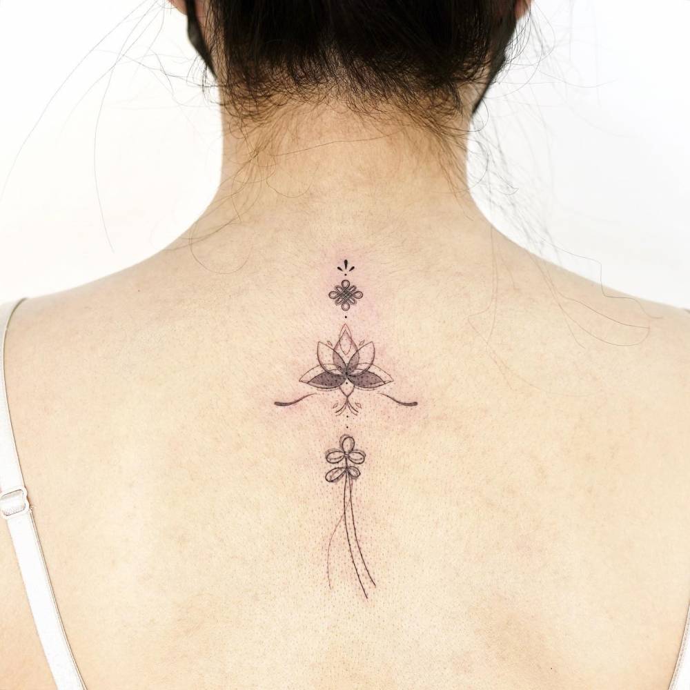 Norigae tattoo located on the upper back.