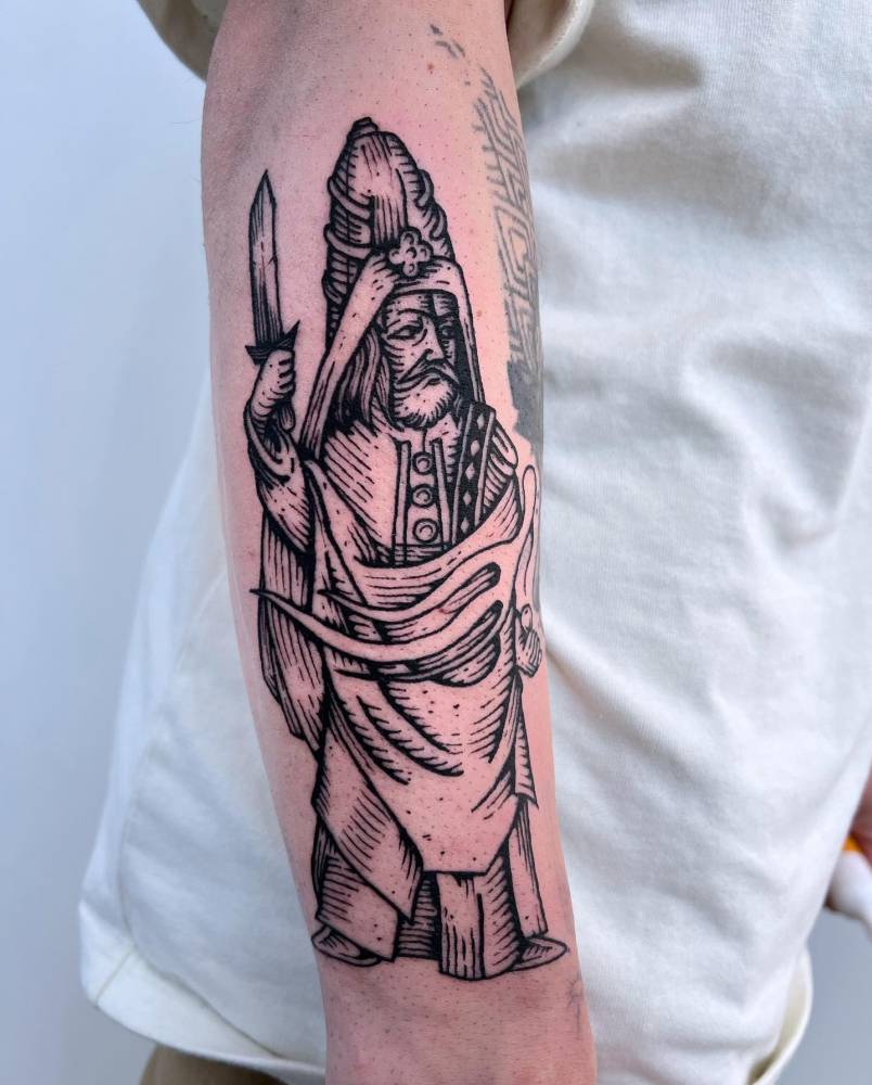 Engraving style wizard tattoo located on the forearm.