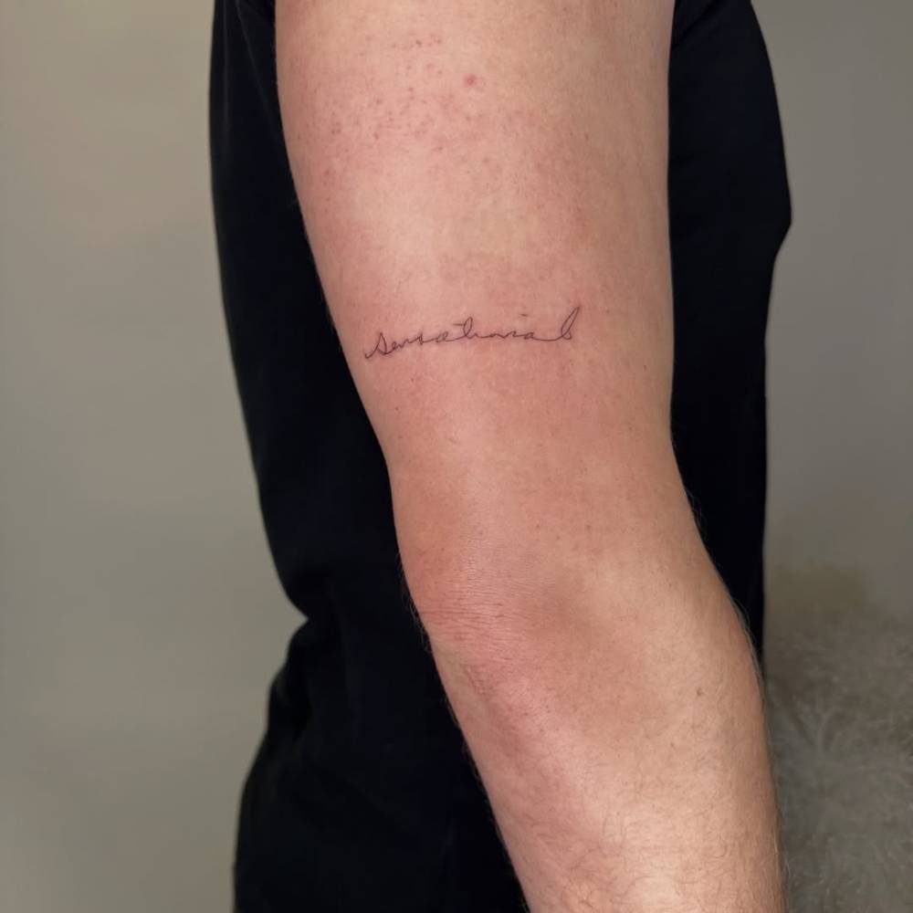 "Sensational" lettering tattoo located on the upper arm.