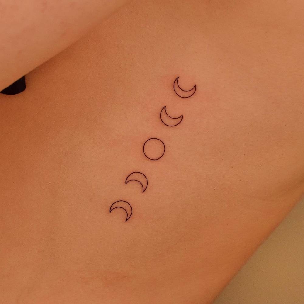 Minimalistic style moon phases tattoo done on the rib.