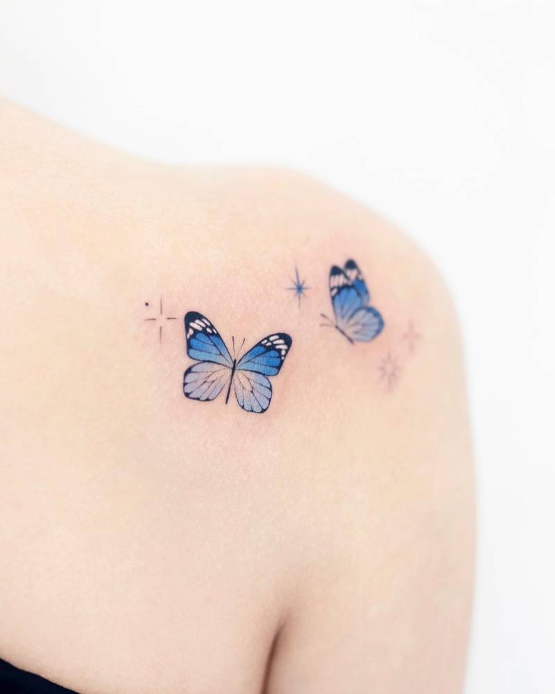 Watercolor style blue butterfly couple tattoo located on the shoulder blade.