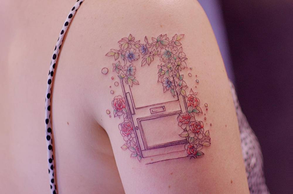 Door and flowers tattoo located on the shoulder, illustrative style.