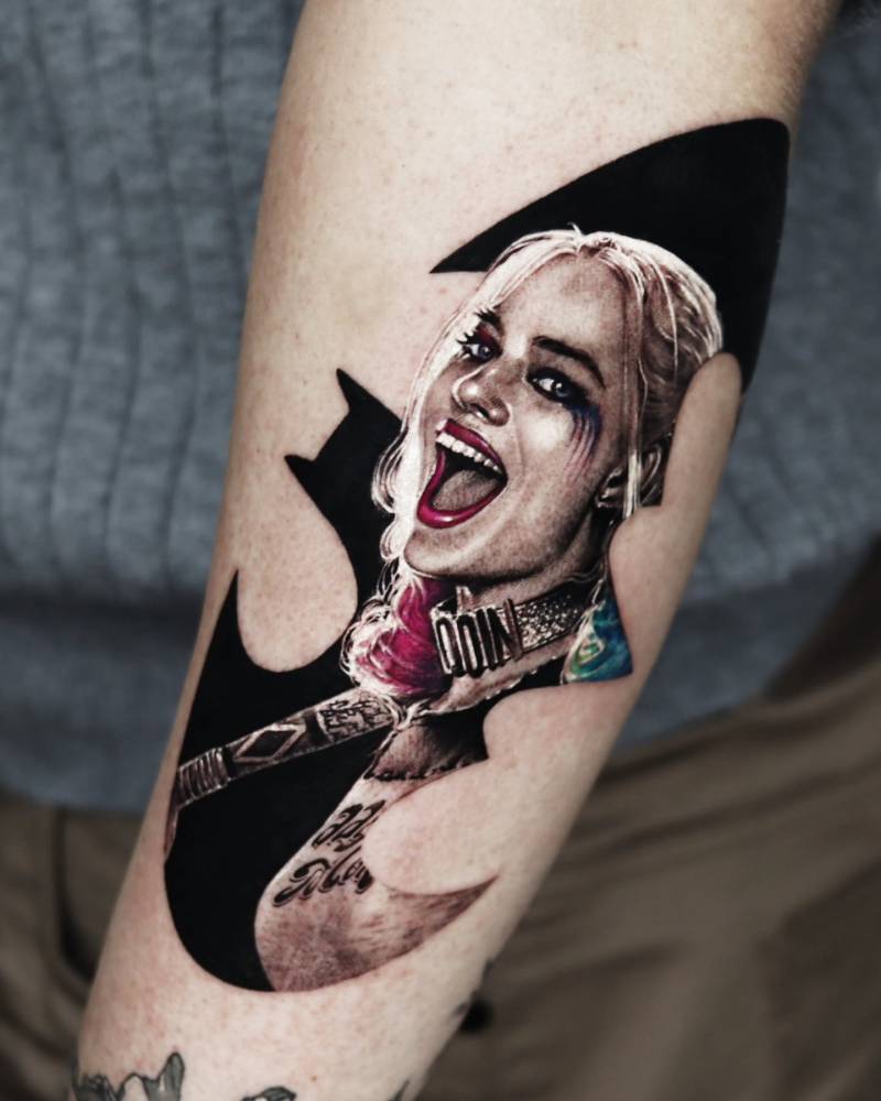 Harley Quinn tattoo located on the forearm, micro-realistic style.