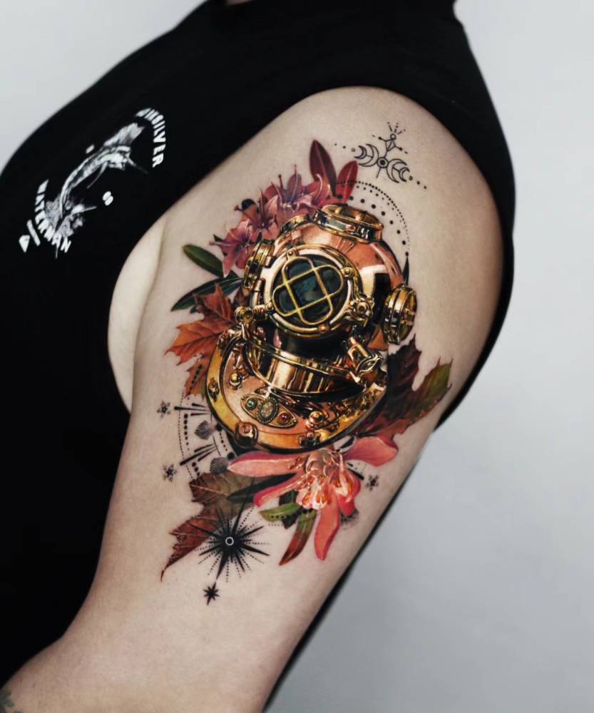 Diving helmet and flowers tattoo located on the upper arm, micro-realistic style.