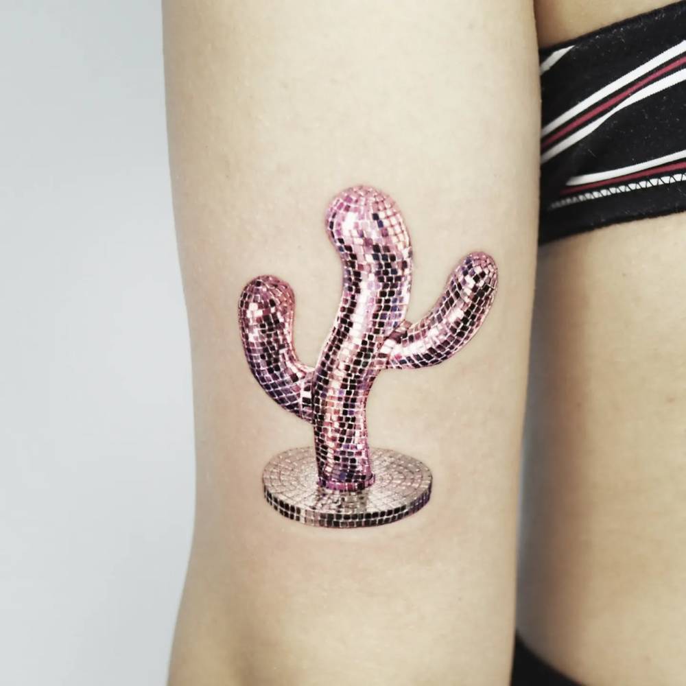 Disco ball cactus tattoo located on the tricep, micro-realistic style.
