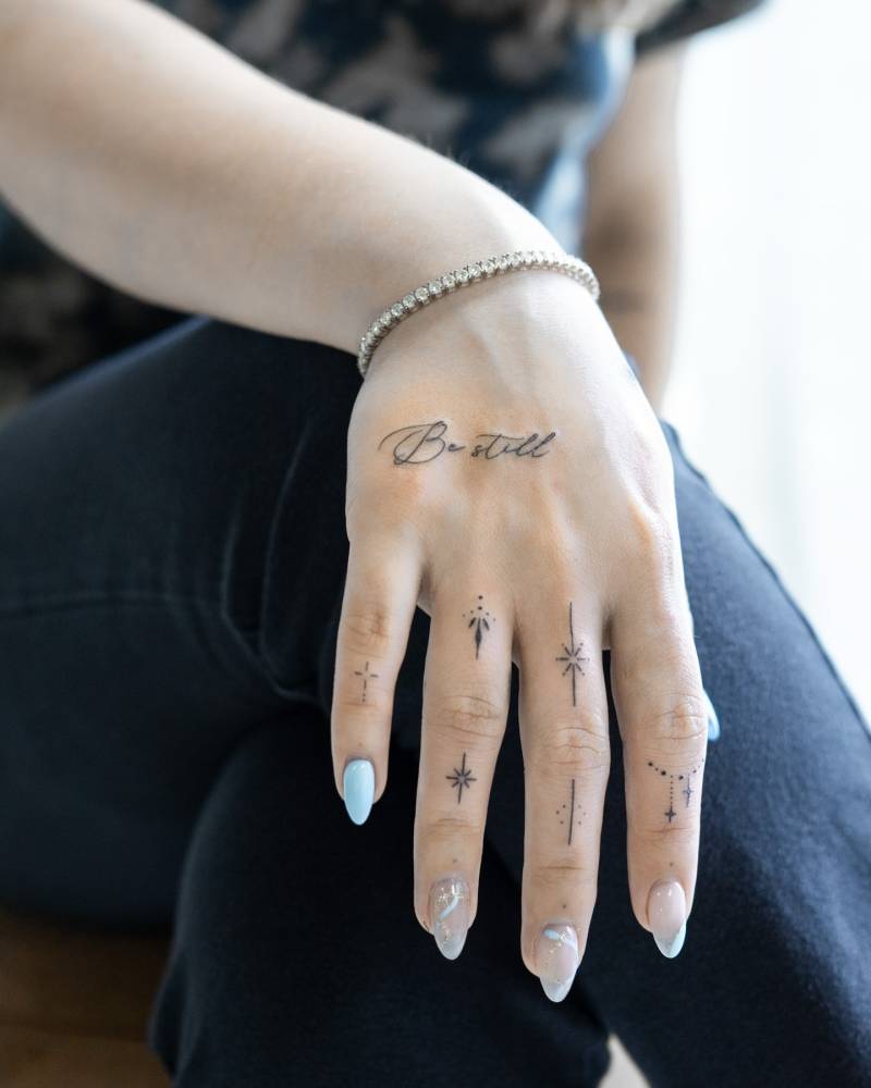 "Be still" and finger ornament tattoos.