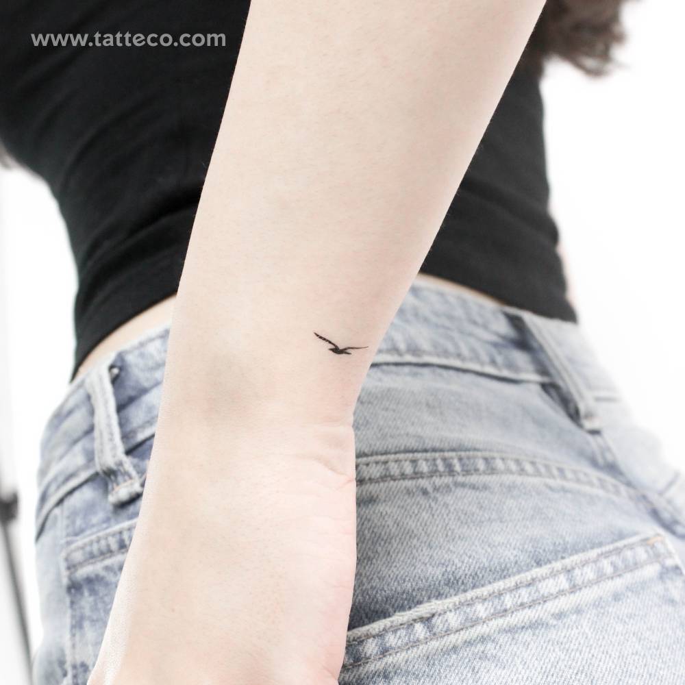 Tiny minimalistic seagull temporary tattoo located on the wrist.