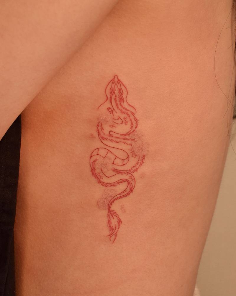 Haku and cherry blossom tattoo located on the rib.