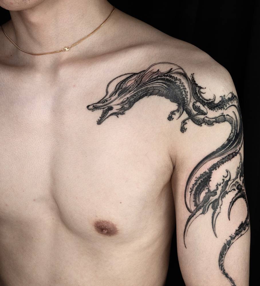 Haku tattoo located on the upper arm and shoulder, blackwork style.