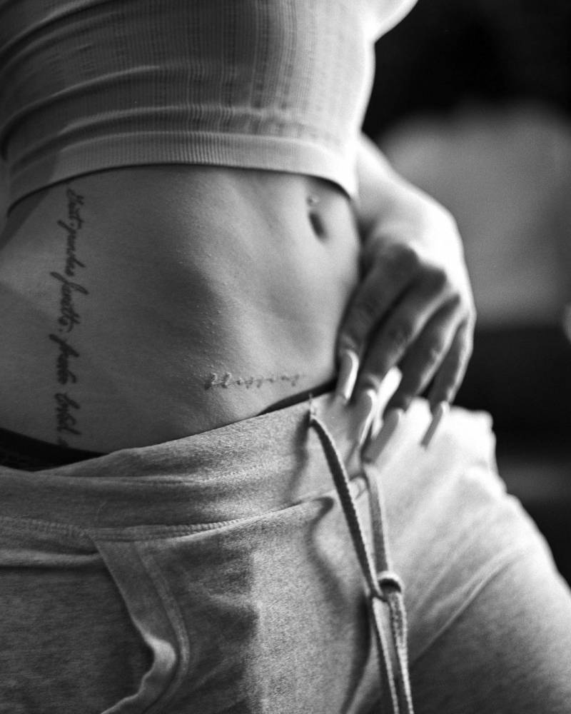 "Blessing" lettering tattoo located on the hip.