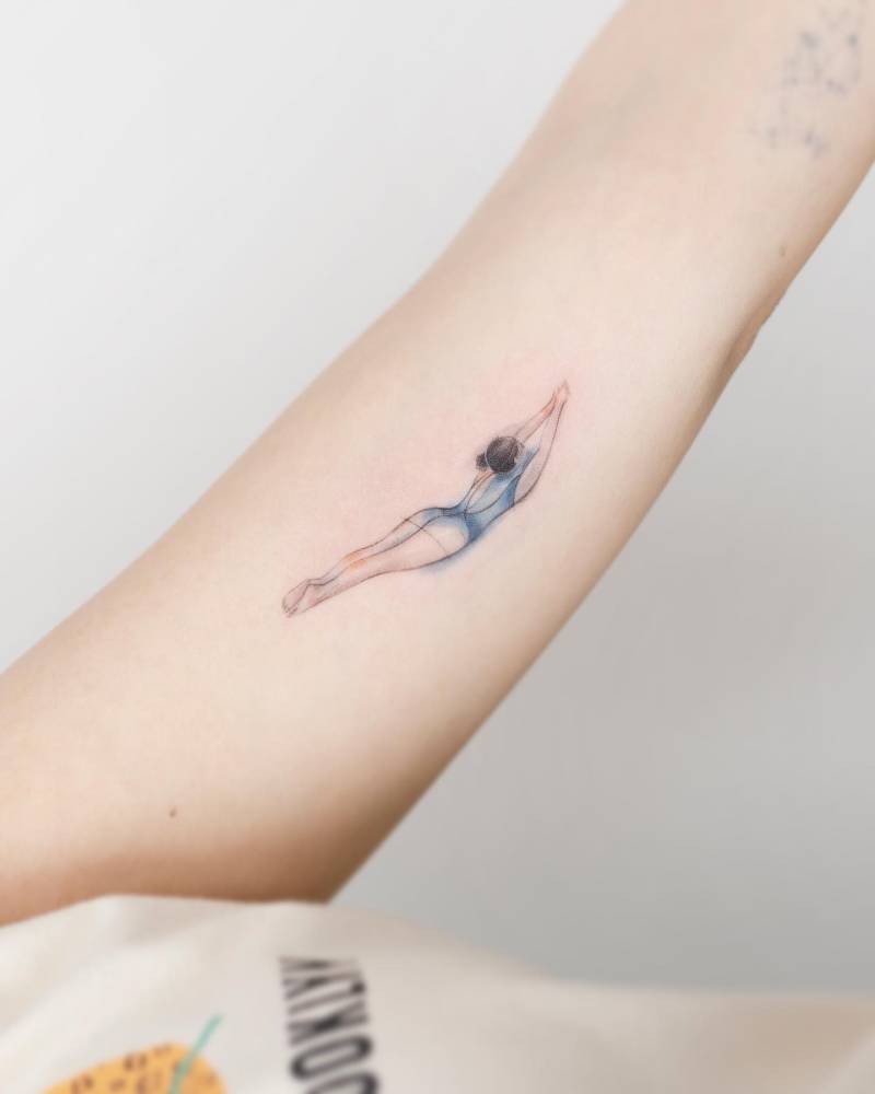 Watercolor style high diving tattoo located on the inner arm.