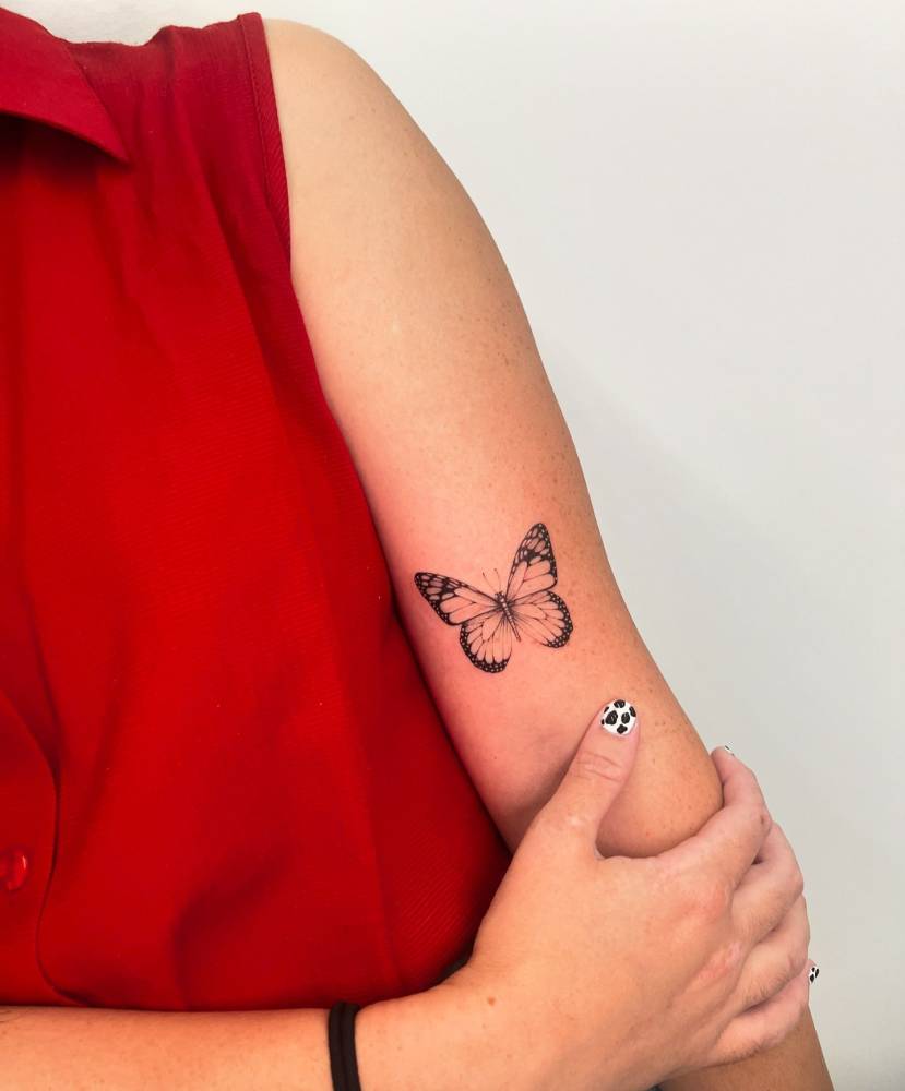 Illustrative style butterfly tattoo located on the bicep.