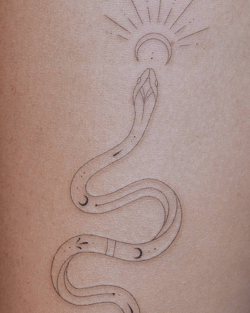 Snake tattoo placed on the inner forearm, done in fine line style.