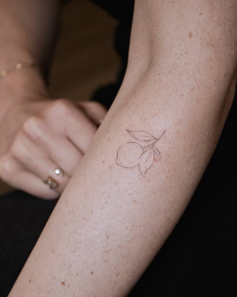 Fine line style lemon tattoo placed on the forearm.