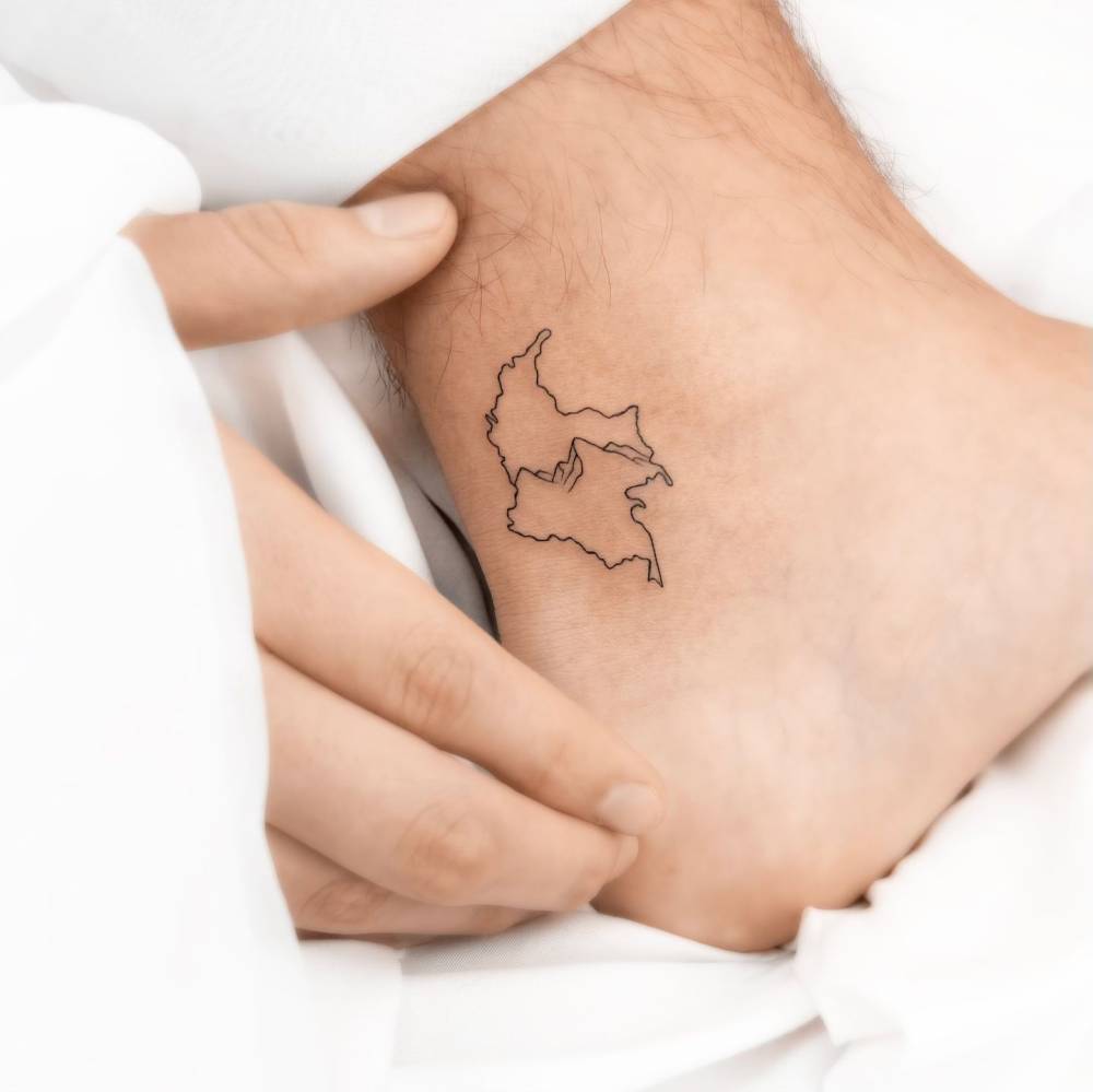 Fine line style Colombia map tattoo located on the ankle.