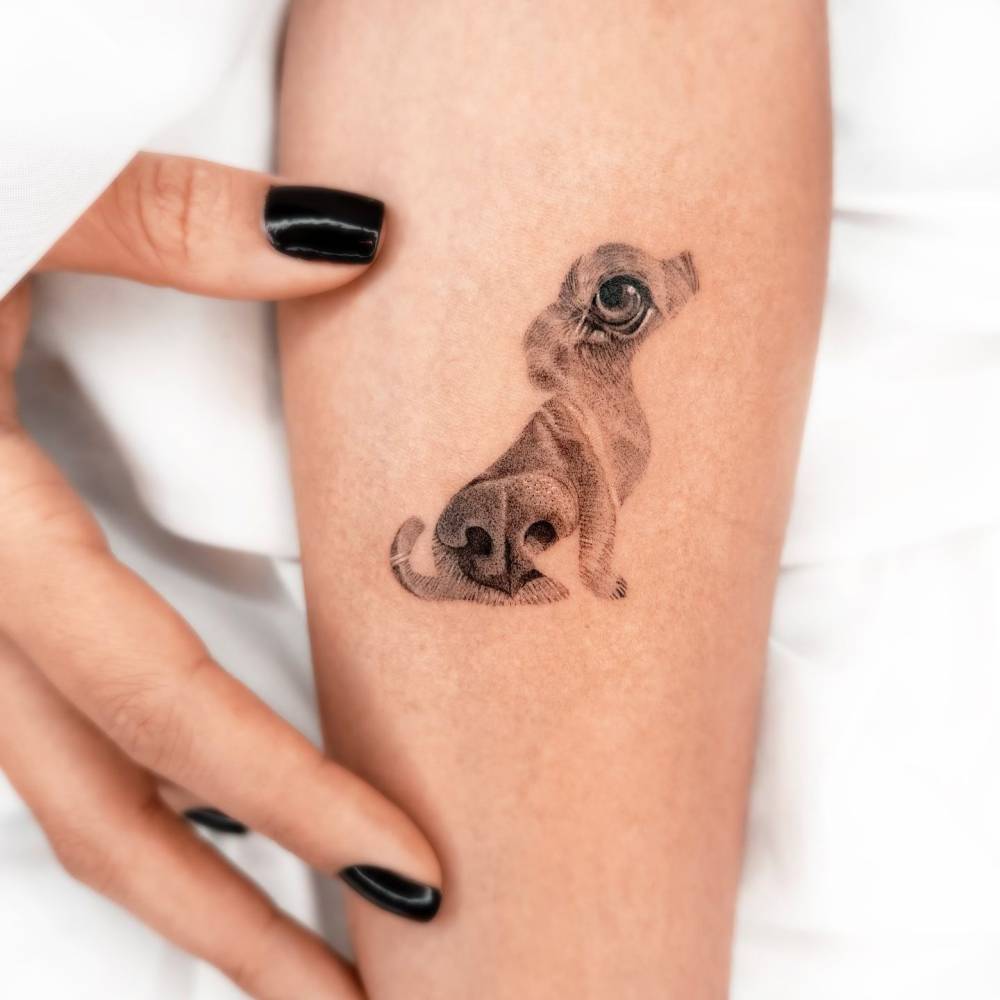 Micro-realistic style dog tattoo located on the inner forearm.