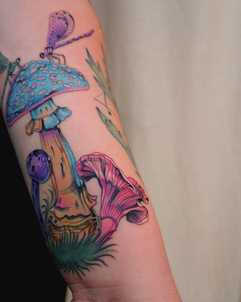 Mushrooms tattoo in illustrative style located on the inner forearm.