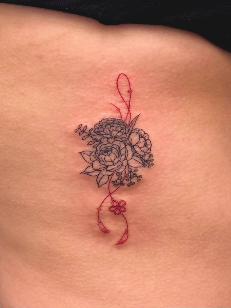 Flower norigae tattoo in fine line style placed on the rib.