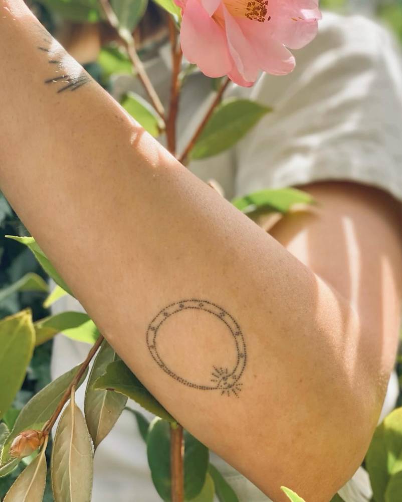 Snake ouroboros tattoo hand poked on the forearm.