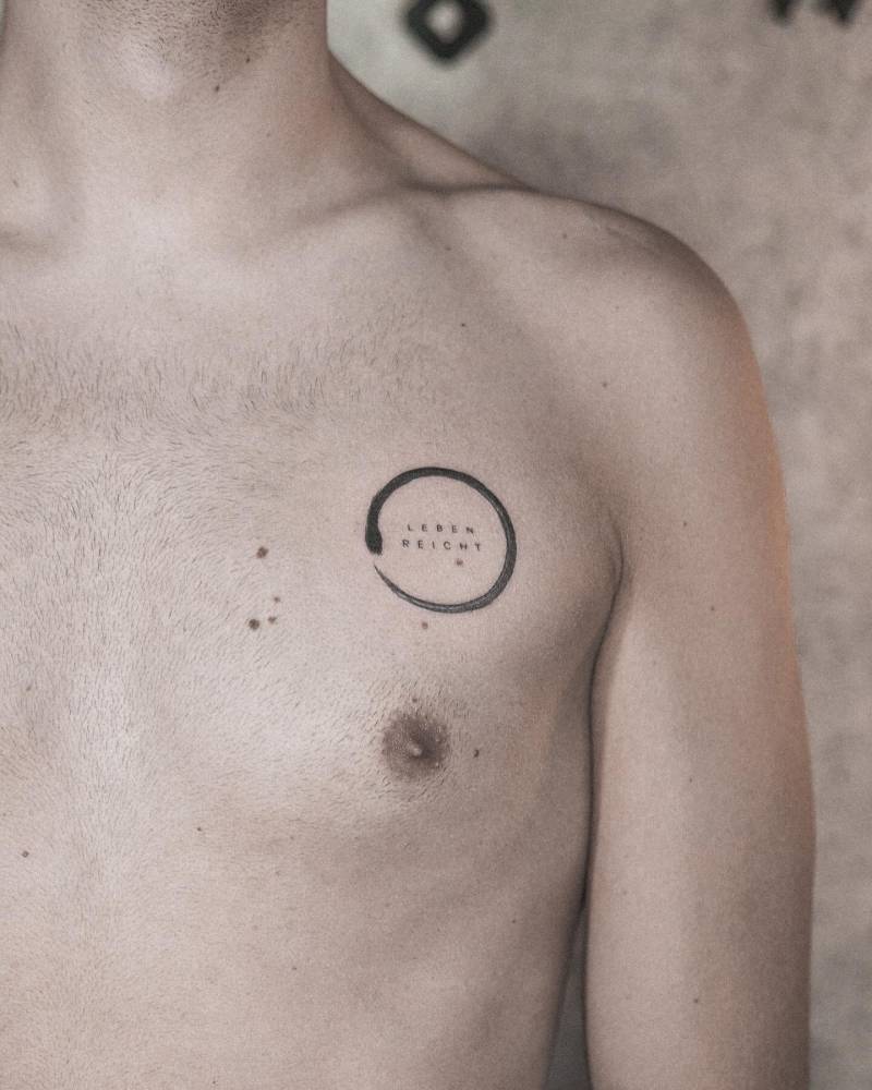 "Leben reicht" and ouroboro tattooed on the chest.