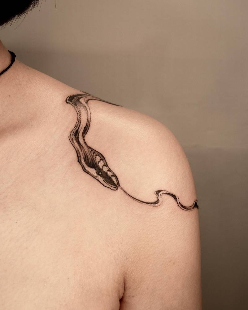 Snake ouroboros tattoo located on the shoulder, blackwork style.