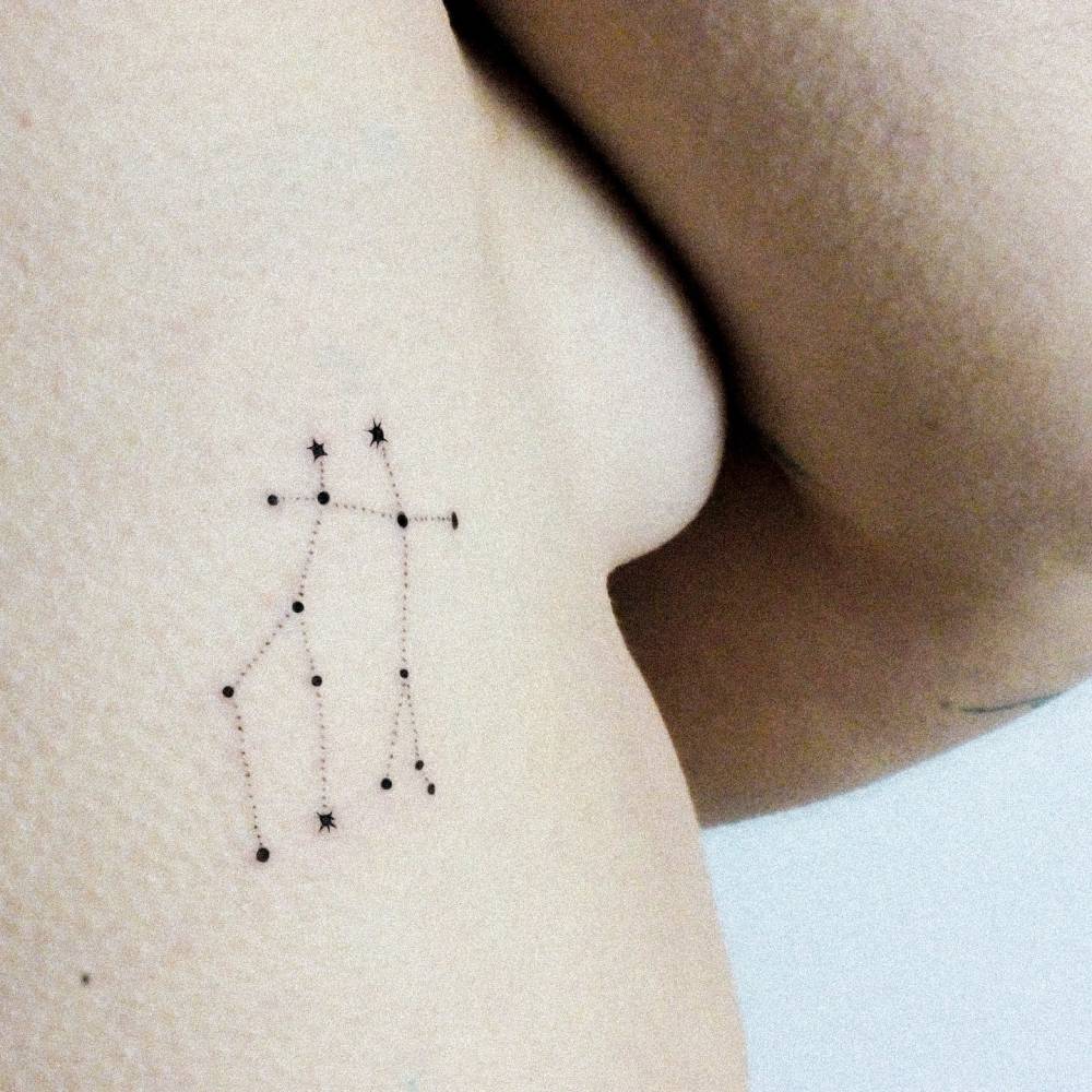 Minimalistic Gemini constellation tattoo placed on the side boob.