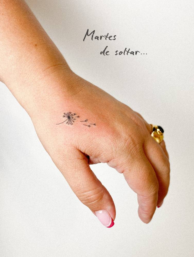 Minimalistic style dandelion tattoo located on the hand.