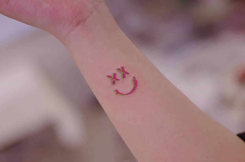 Louis Tomlinson's smile tattooed on the wrist.