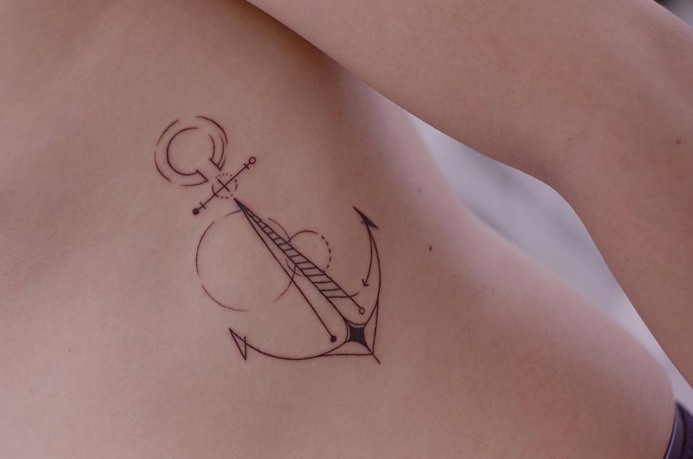 Line art style anchor tattoo located on the rib.