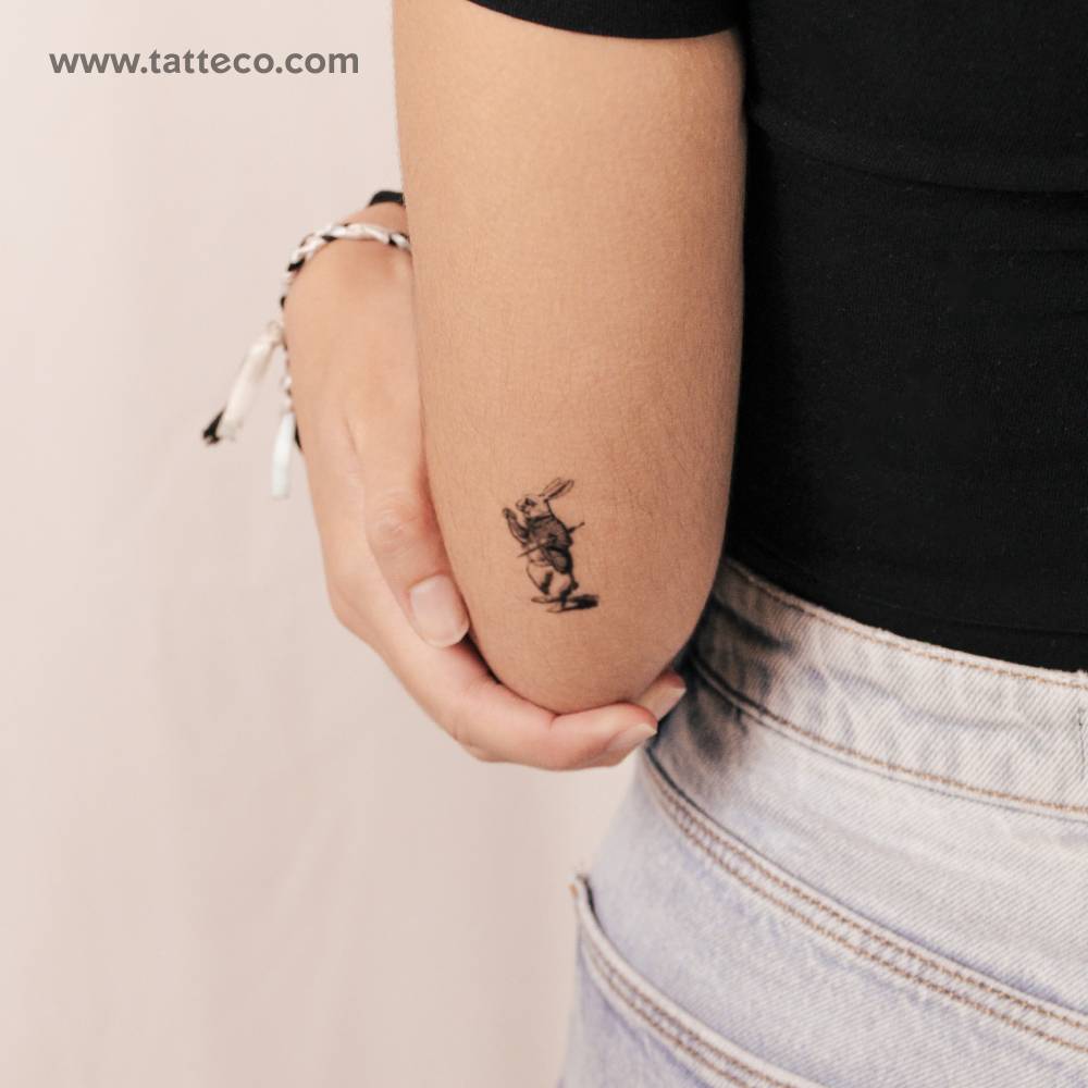 White rabbit semi-permanent tattoo located on the tricep.