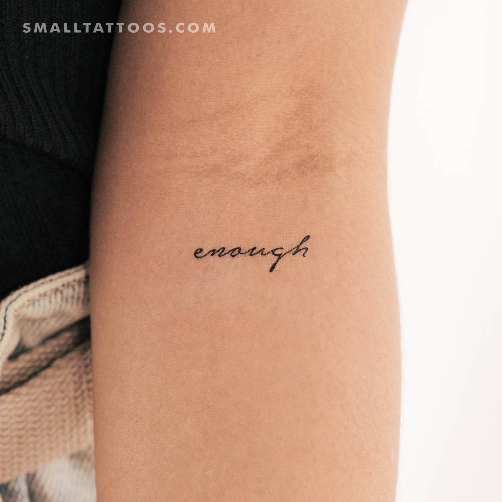 Handwritten font word "enough" temporary tattoo located on the inner forearm.