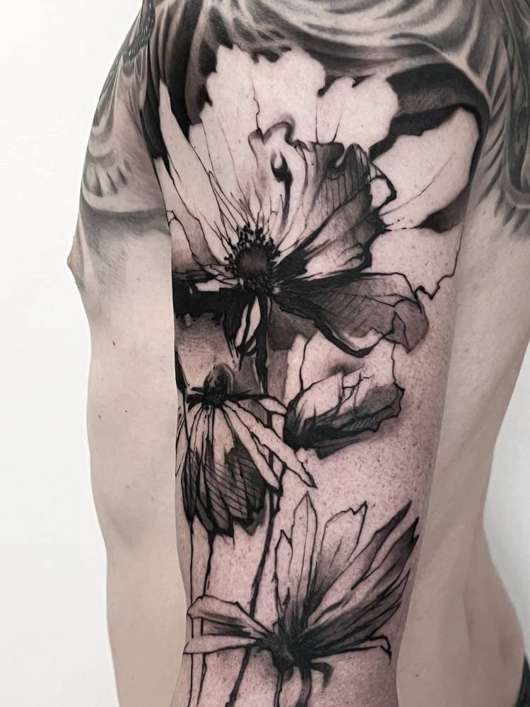 Blackwork style flowers tattoo located on the upper arm.