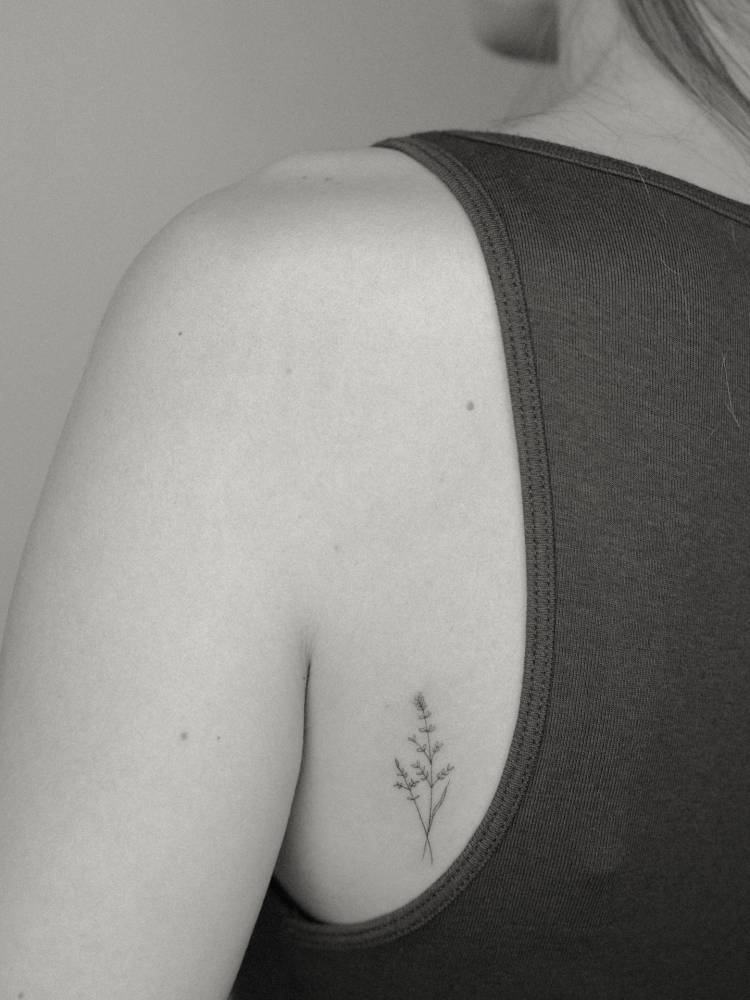 Wild grass tattoo in fine line style located on the back.
