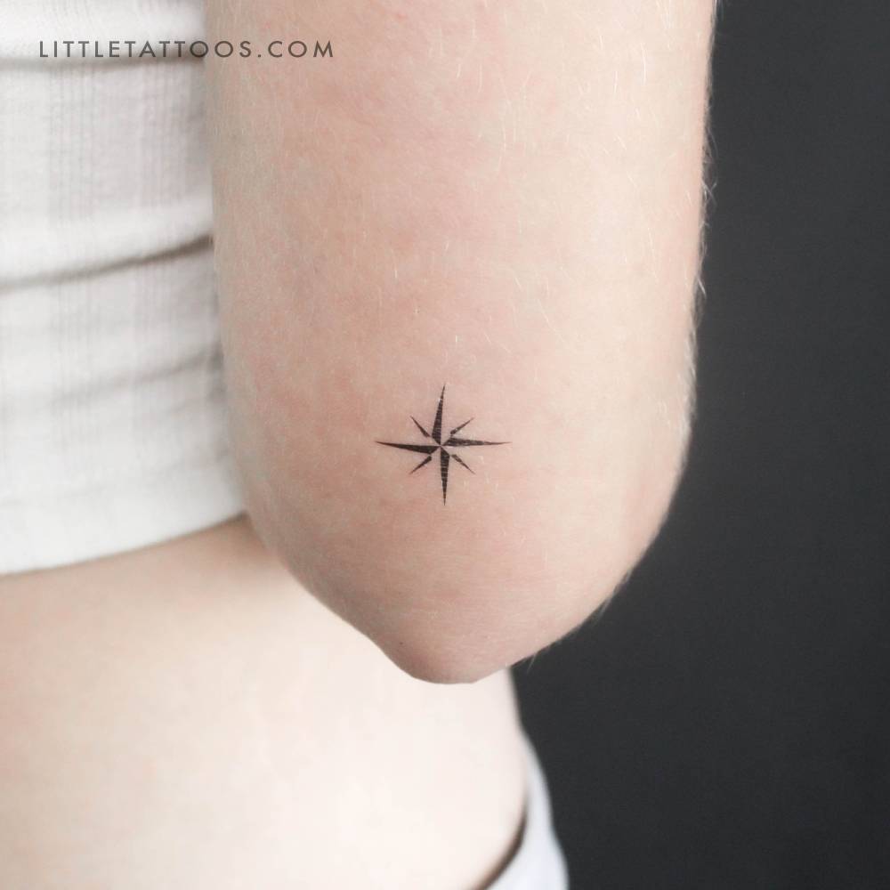 Small minimalist compass temporary tattoo located on the tricep.
