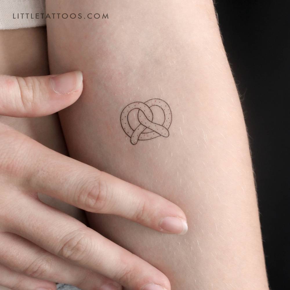 Pretzel temporary tattoo in fine line style located on the inner forearm.