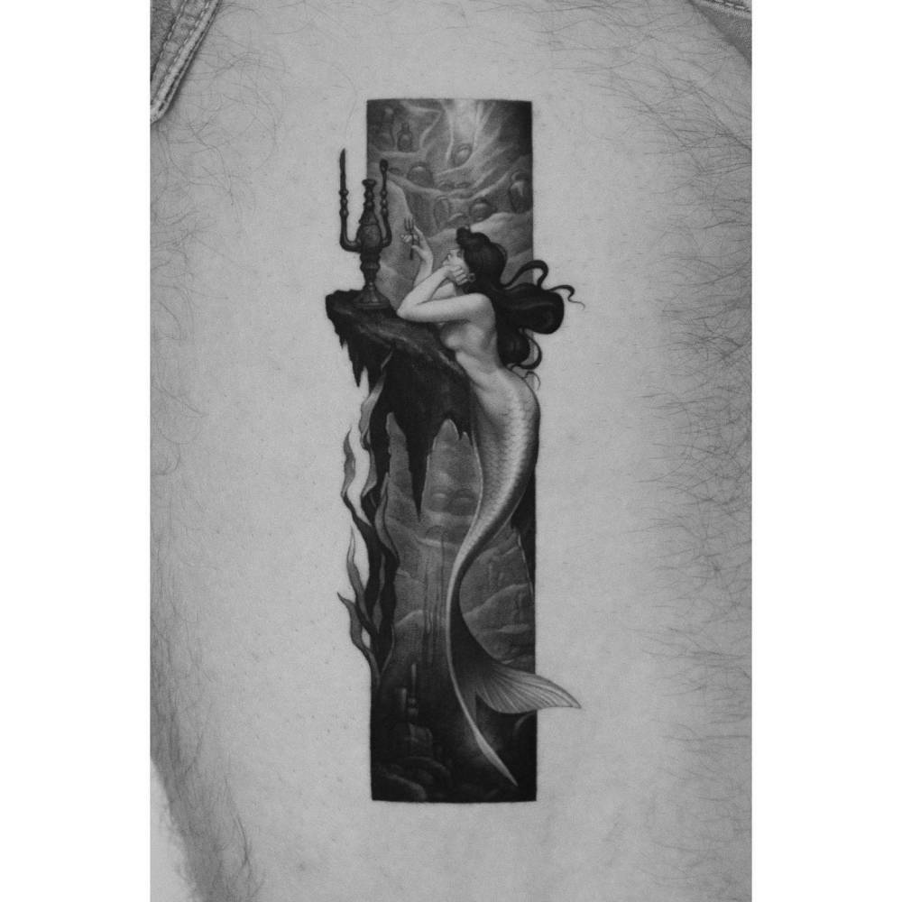 Micro-realistic style mermaid tattoo located on the thigh.