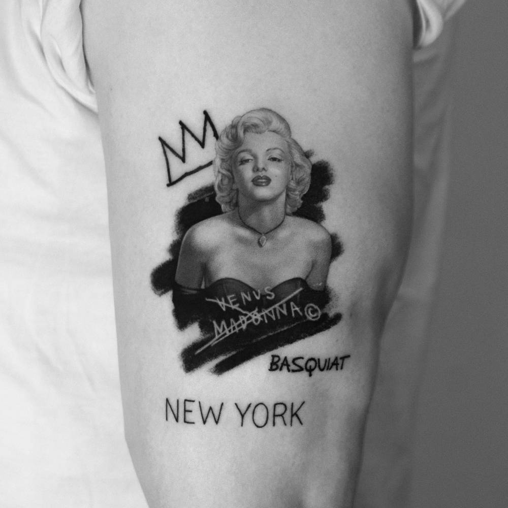 Pop art style Marilyn Monroe tattoo located on the upper arm.