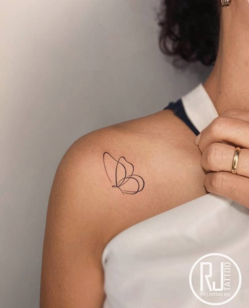 Line art style butterfly tattoo located on the shoulder.