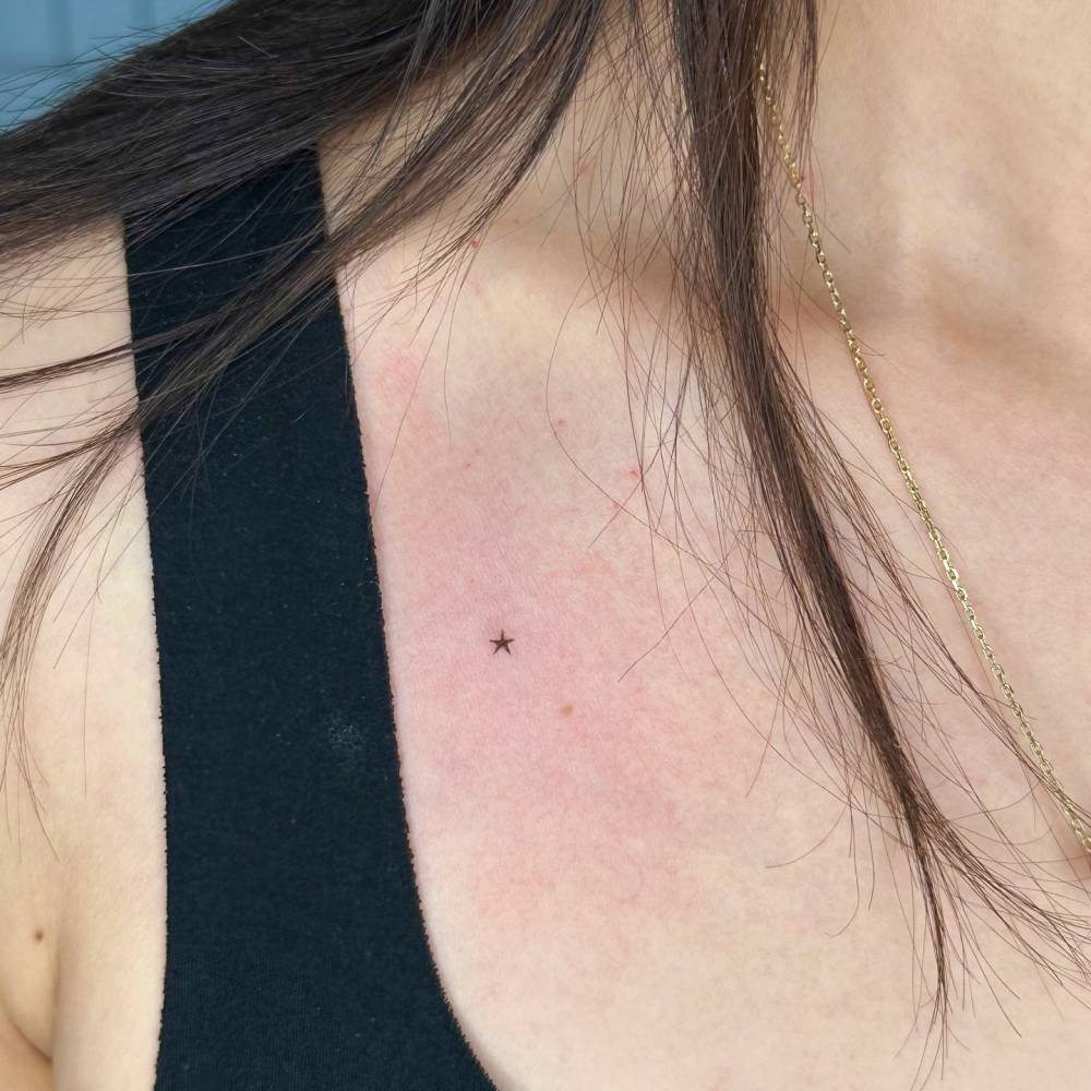 Tiny minimalistic star tattoo hand poked on the chest.