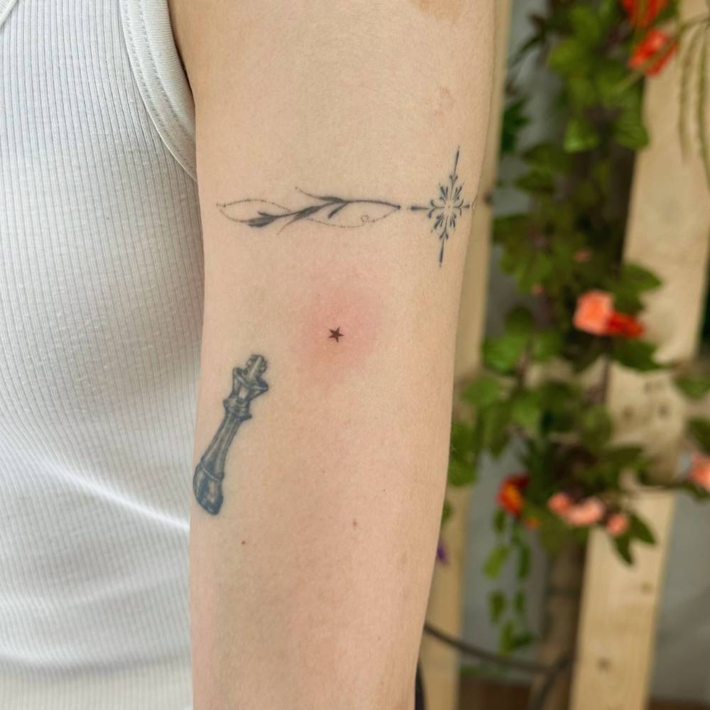 Hand poked micro star tattoo located on the upper arm.
